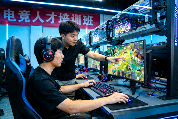 电竞人才培训班课堂上，学员正在操作专业设备，导师进行指导